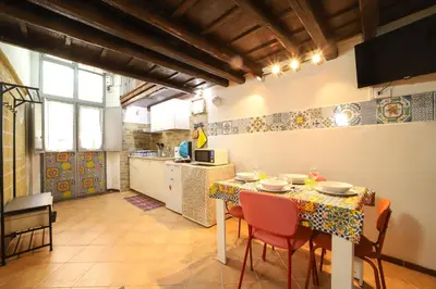 a kitchen with a table and chairs in a room at Ballarua in Palermo
