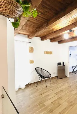 a room with a chair and a television on a wall at La Casetta in Piazza in Palermo
