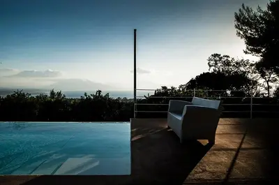 a white chair sitting next to a swimming pool at Casa Portico, con piscina in comune in Terrasini