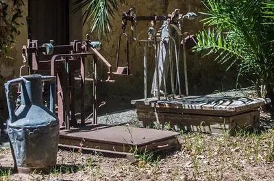 an old water fountain in a yard next to a building at Casa Portico, con piscina in comune in Terrasini