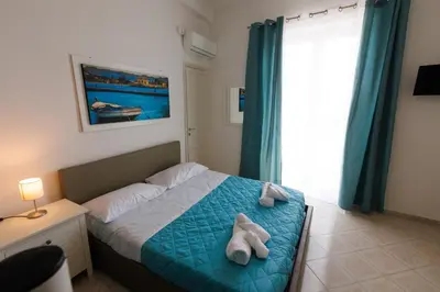 a bedroom with a bed with towels on it at Donna Rosalía Apartments in Trabia
