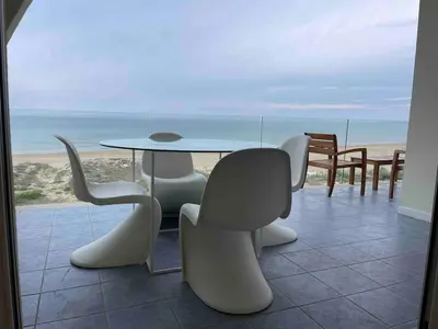 a table and chairs with a view of the beach at Appartamento sulla Spiaggia in Alcamo