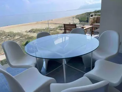 a glass table and chairs with a view of the beach at Appartamento sulla Spiaggia in Alcamo