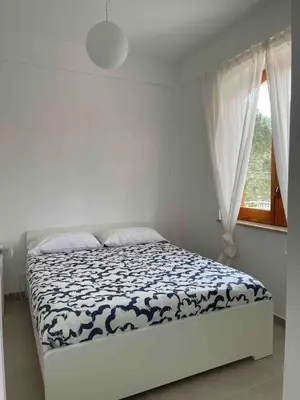 a bed in a white room with a window at Appartamento sulla Spiaggia in Alcamo
