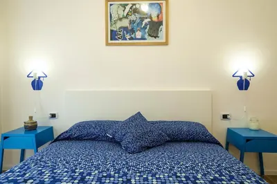 a bedroom with a blue bed with two blue tables at MAD Bed & Breakfast in Palermo