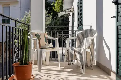 two white chairs on a balcony with a cactus at Luce mediterranea a Monreale in Monreale