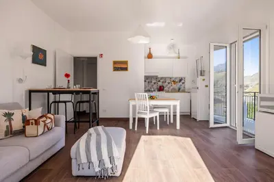 a living room with a couch and a table and a kitchen at Luce mediterranea a Monreale in Monreale