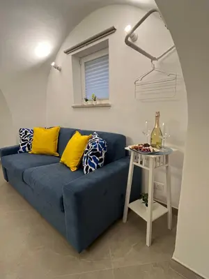 a blue couch in a living room with a table at Palazzo dei Duchi D'Amico - Apartment -
