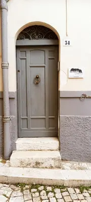 a door to a building with stairs in front at Beneath the Castle in Corleone