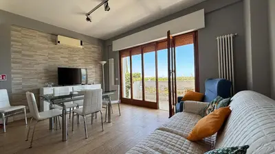 a living room with a couch and a dining room at Villa Emilia Mondello Appartamento Vita Alba con vista sul mare in Mondello