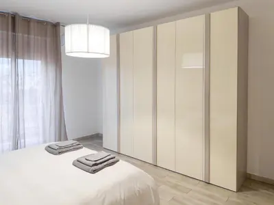 a white bedroom with a bed with towels on it at Casa Belsito in Palermo