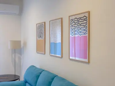 a living room with a blue couch and three pictures at Casa Belsito in Palermo