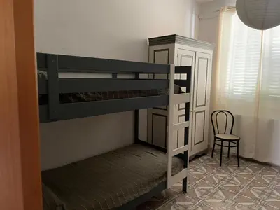 a bedroom with two bunk beds and a chair at Casa vacanze dispensa San Pietro in Calatafimi