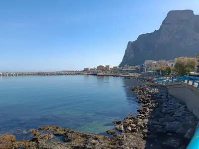 a body of water with a mountain in the background at La casetta di Cecilia in Palermo