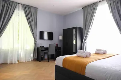 a bedroom with a bed and a desk with a computer at Mazzini Suites Palermo in Palermo