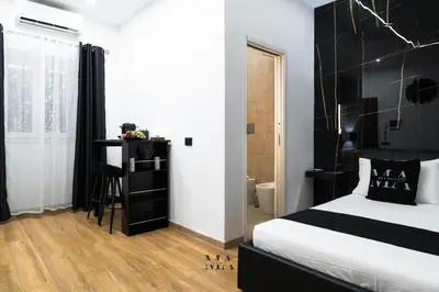 a bedroom with a bed with a black headboard at MEA Suite in Palermo