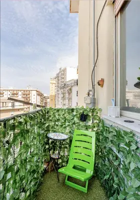 a green chair and a table on a balcony at Dolce Sicily a 1km dal centro in Palermo