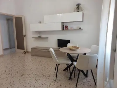 a dining room with a table and white chairs at Dolce Sicily a 1km dal centro in Palermo