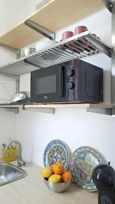a kitchen counter with a microwave and a bowl of fruit at Esse & Emme in Palermo