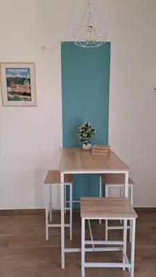 a table and bench in a room with a blue wall at Esse & Emme in Palermo