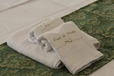 two towels sitting on top of a bed at Leoni di Sicilia in Palermo