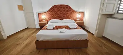 a bedroom with a large bed with a large headboard at Leoni di Sicilia in Palermo