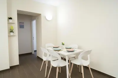 a white dining room with a white table and white chairs at Casetta di Giulio in Palermo
