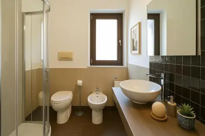 a bathroom with a sink and a toilet and a glass shower at Casetta di Giulio in Palermo
