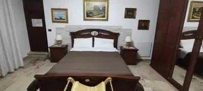 a bedroom with a wooden bed with two night stands at Casa Emma 121 in Partinico