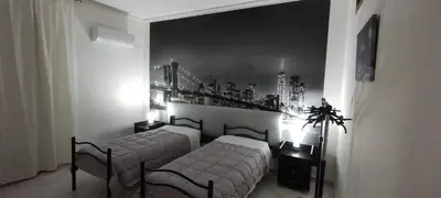 a bedroom with two beds and a bridge on the wall at Casa Emma 121 in Partinico