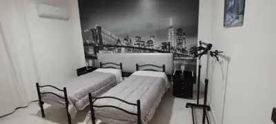 two beds in a room with a bridge on the wall at Casa Emma 121 in Partinico