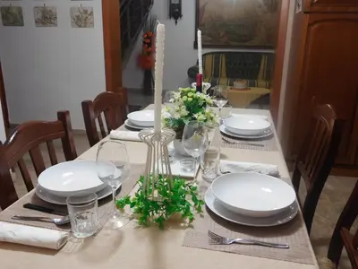 a dining table with white plates and flowers on it at Casa Emma 121 in Partinico
