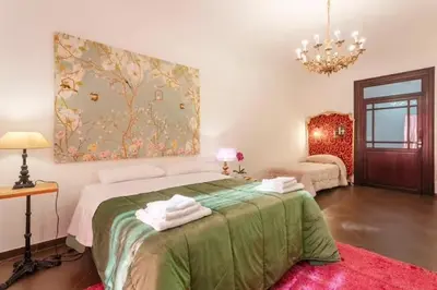 a bedroom with a large bed with a green blanket at Casa Lulú in Palermo