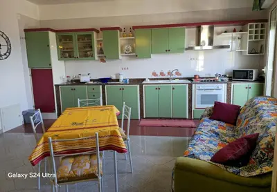 a kitchen with green cabinets and a couch and a table at GiRosa House in Bagheria