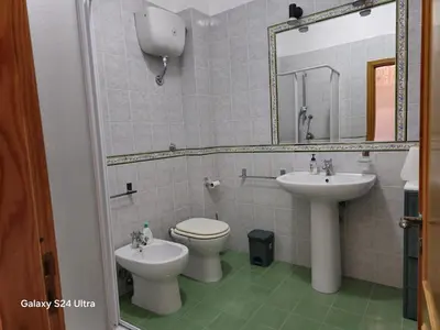 a bathroom with a sink and a toilet and a mirror at GiRosa House in Bagheria
