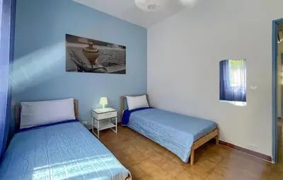 a bedroom with two beds and a table with a lamp at Stunning Apartment In Balestrate in Balestrate