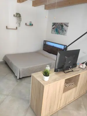 a bedroom with a bed and a television on a desk at Central apartment with charm for 1 or 2 people - Casa Vacanze Luna in Lascari