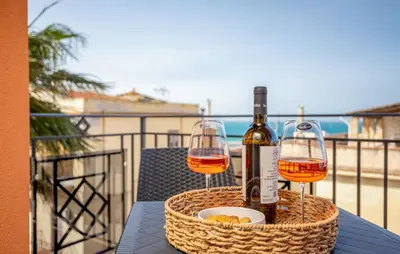 two glasses of wine on a table on a balcony at Beautiful Apartment In Balestrate in Balestrate