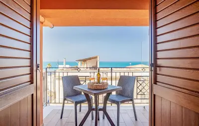 a table and chairs on a balcony with a view of the ocean at Beautiful Apartment In Balestrate in Balestrate