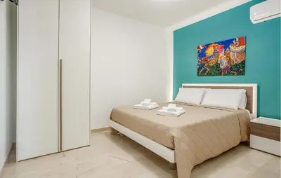 a bedroom with a bed and a painting on the wall at Beautiful Apartment In Balestrate in Balestrate