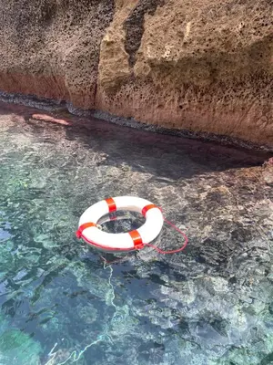 an orange and white life buoy in the water at Aspra Mare House in Ficarazzi