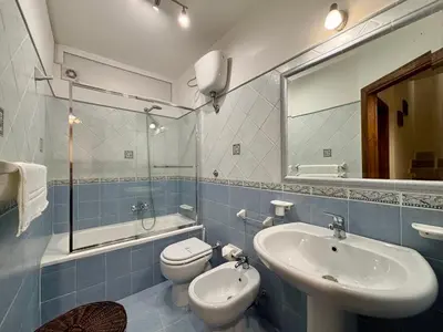 a bathroom with a sink and a toilet and a mirror at Aspra Mare House in Ficarazzi