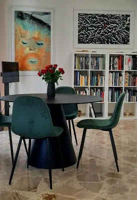a dining room with a table and green chairs at Casa d'artista Max Serradifalco in Palermo