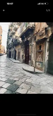a stone street with an old building on the side at Casa Mortillaro - The Heart of Palermo, Ballaro Market in Palermo