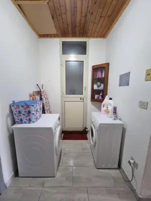 a bathroom with two washing machines and a door at La Maison in Palermo