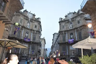 a group of people walking down a street in front of buildings at Sweet dreams AF in Palermo