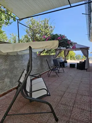 a patio with chairs and an umbrella and a table at IL GEKO tra Palermo e Cefalu' nel mare di Sicilia in Trabia