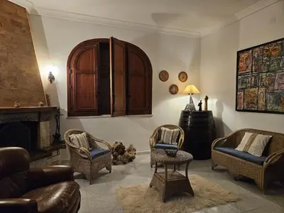 a living room with chairs and a couch and a fireplace at IL GEKO tra Palermo e Cefalu' nel mare di Sicilia in Trabia