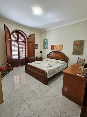 a bedroom with a bed and a table and a desk at IL GEKO tra Palermo e Cefalu' nel mare di Sicilia in Trabia