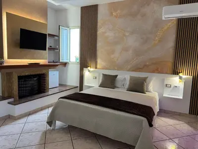 a bedroom with a large bed and a fireplace at From Flori in Terrasini